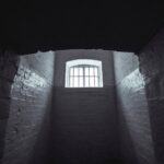 Prison cell with bars and light pouring in